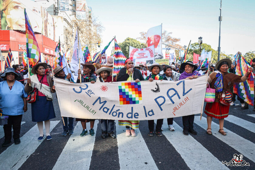 Integrantes del Tercer Malón de la Paz marchan con una bandera con una whipala, con sombreros y trajes tradicionales de Jujuy.